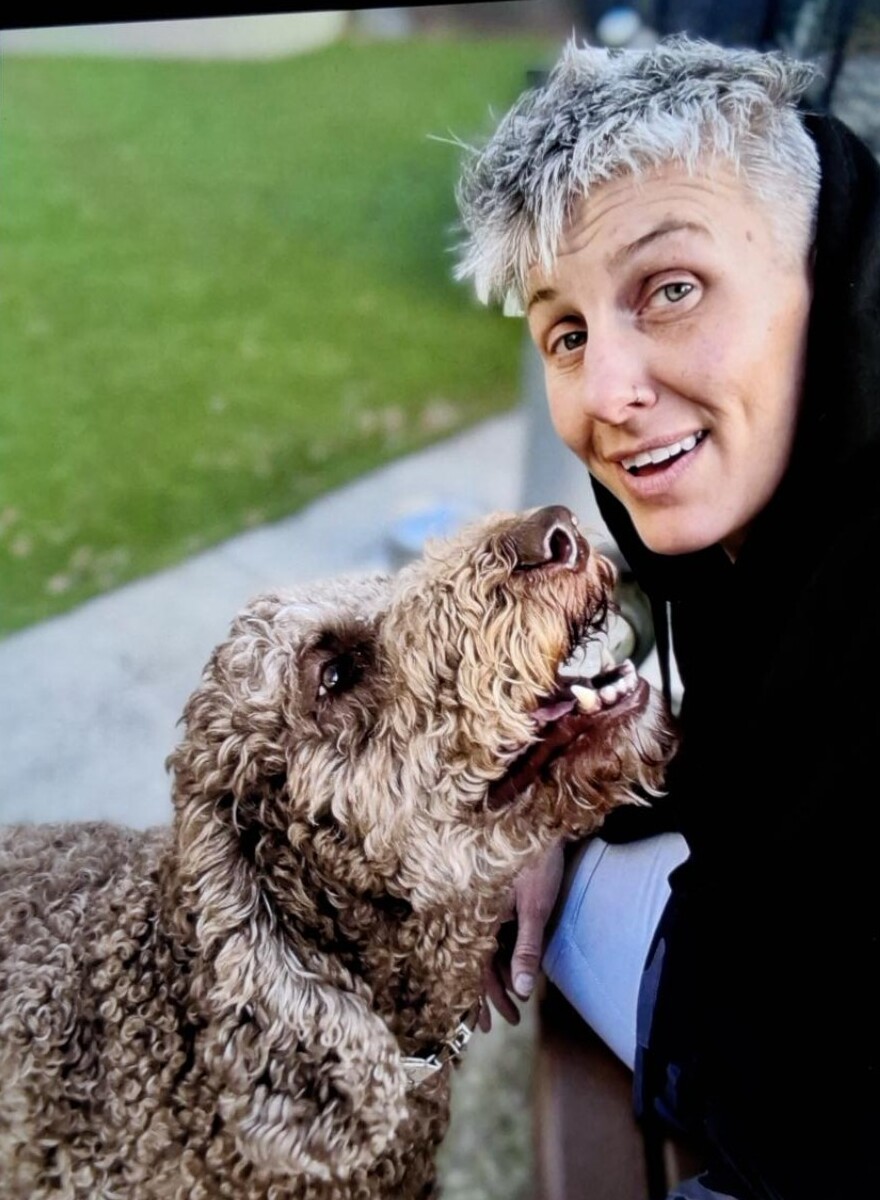 Nikki sharing a happy moment with a curly-haired dog